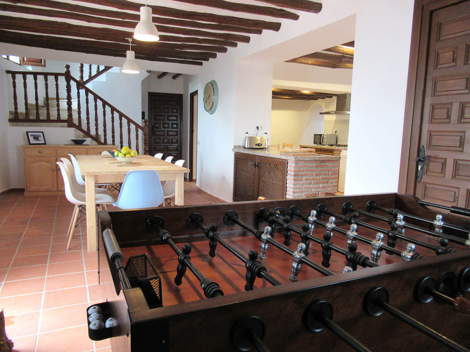 Open plan kitchen and dining room with table set for nine people.