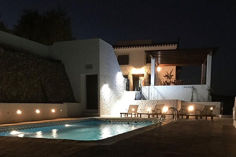 The pool and jacuzzi lit up by night