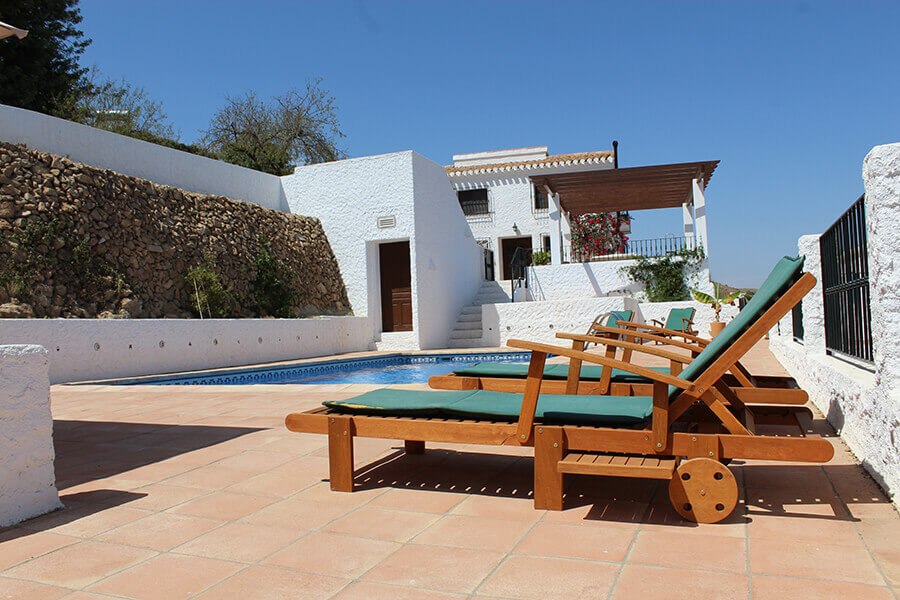 The gated pool terrace with sunloungers